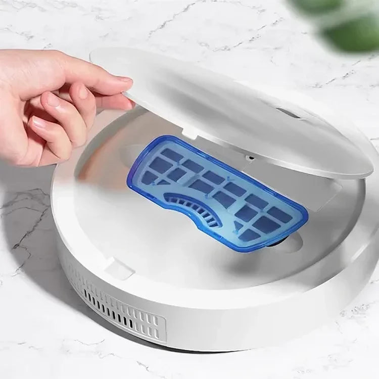 A hand opening the dustbin compartment of a TU SHOP robot vacuum cleaner.