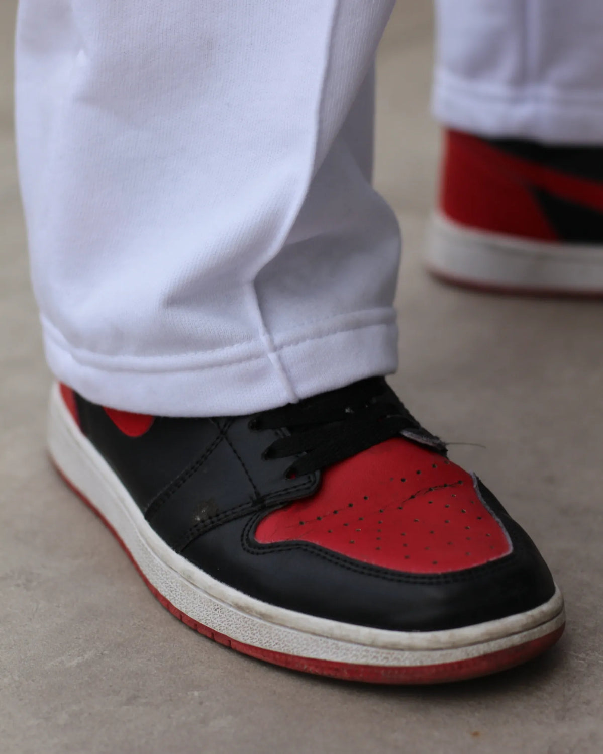 Black and red urban sneakers worn with white sweatpants from TU SHOP